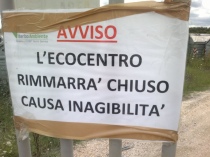 Il cartelllo (con errore grammaticale) apposto all'esterno dell'ecocentro alla Volpara. Sulla destra si nota il manto stradale asciutto